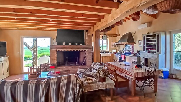 Un interior rústico con chimenea, comedor y cocina.