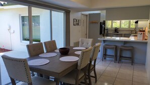 A dining area with a table, chairs, and a kitchen in the background. - Dreamin O'Sprey! Amazing View & Plenty O'Privacy! (Clermont)