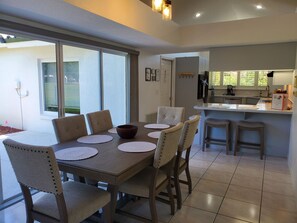 A dining area with a table, chairs, and a kitchen in the background. - Dreamin O'Sprey! Amazing View & Plenty O'Privacy! (Clermont)