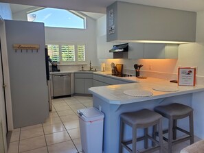 A modern kitchen with a built-in island, bar stools, a dishwasher, and a sign indicating a smoking-free area. - Dreamin O'Sprey! Amazing View & Plenty O'Privacy! (Clermont)