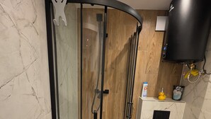 Un baño moderno con ducha de vidrio, inodoro y lavamanos.