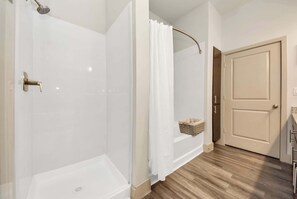 A bathroom with a shower, a toilet, and a sink.