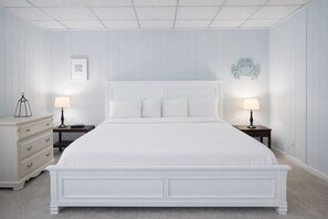 A white four-poster bed with two bedside tables, each with a lamp, in a room with white walls and a carpeted floor. - IR20 Walk to Sandfest, Shared Pools, Boardwalk to Beach (Port Aransas)