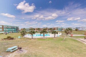 A residential area with a swimming pool, palm trees, and a picnic table. - IR20 Walk to Sandfest, Shared Pools, Boardwalk to Beach (Port Aransas)
