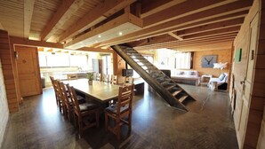 A wooden interior with a dining area, staircase, and kitchen. - Le grand gîte de Combes (BESSE ET SAINT ANASTAISE)