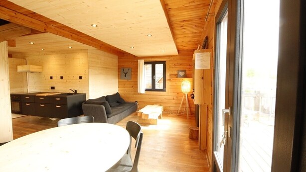 A modern interior with a dining area, kitchen, and a large window.