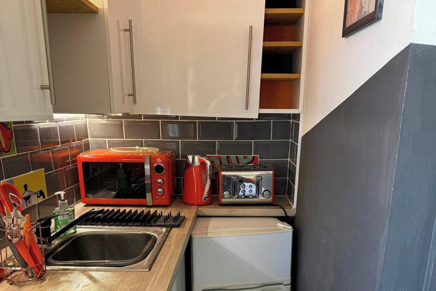 Une cuisine équipée d’un four à micro-ondes, d’un grille-pain et d’un évier.