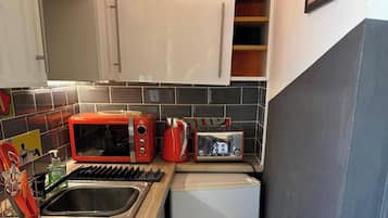 Une cuisine équipée d’un four à micro-ondes, d’un grille-pain et d’un évier.
