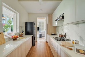 A modern kitchen with a central island, wooden cabinets, and a view into the living area.