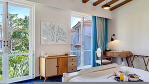 A bedroom with a bed, a desk, a chair, a dresser, and a large window with a view of greenery. - Villa Sai Shukhrana 3bhk w Private Pool in Moira (Moira)