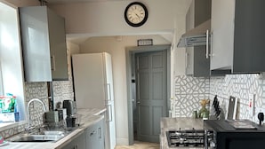 Uma cozinha moderna com máquina de lavar integrada, micro-ondas e fogão a gás.