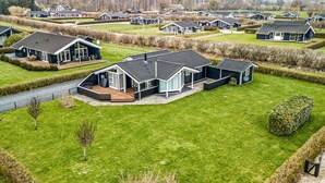 Ein modernes Wohngebiet mit mehreren Häusern, gepflegten Rasenflächen und freiem Blick auf die umliegende Landschaft.