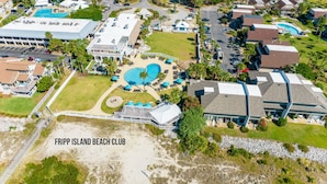 Eine Vogelperspektive des Fripp Island Beach Club mit einem großen Pool, mehreren Gebäuden und dichter Bepflanzung.