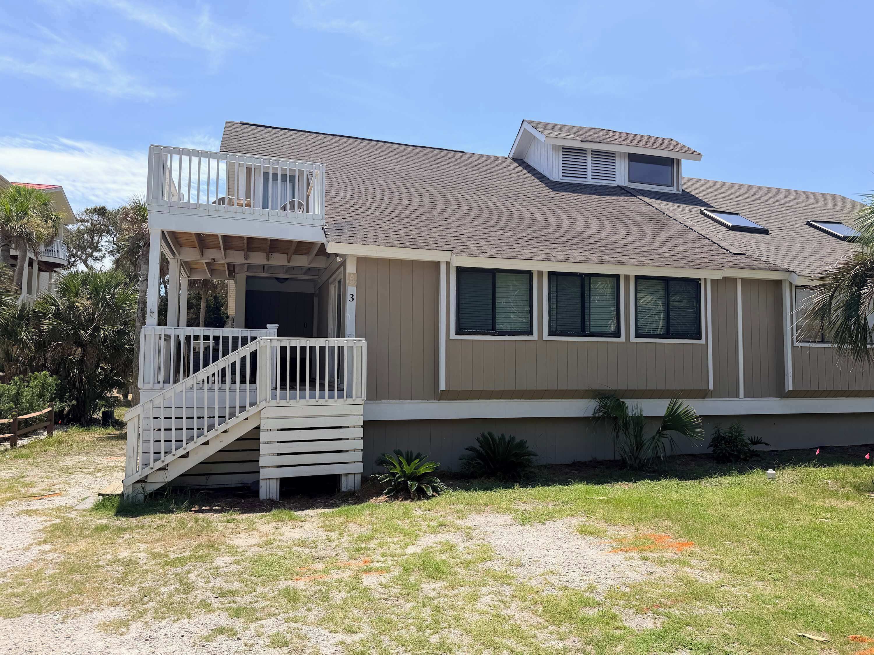 A two-story house with a balcony, a covered porch, and a small attached garage.