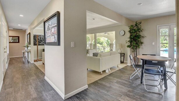 A spacious living area with a dining table, a sofa, and a large window offering a view of the outdoors. - Las Vegas Quiet Compound (Las Vegas)