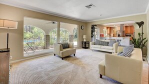 A spacious living room with large windows, a fireplace, and a kitchen in the background. - Las Vegas Quiet Compound (Las Vegas)