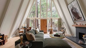Ein gemütliches Wohnzimmer mit großem Fenster, Kamin und einer bequemen Sitzecke.