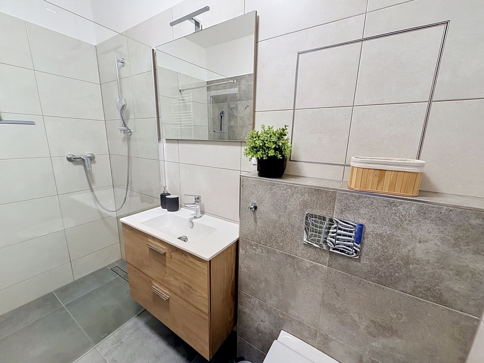Ein modernes Badezimmer mit Dusche, Waschbecken und Waschtisch.