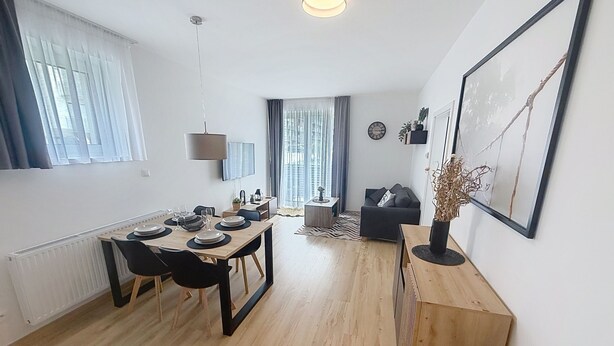 Un appartement moderne comprenant un coin repas, un salon et une cuisine.