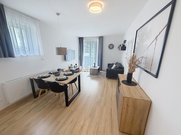 A modern apartment with a dining area, a living room, and a kitchen.