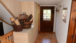 A wooden staircase leading to a door with baskets of firewood on the landing. - Obergasse Ferienhaus, Dusche oder Bad, WC Ferienhaus by Interhome (Wiesen)