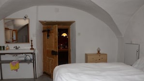 A bedroom with a bed, a dresser, a mirror, a door leading to a hallway, and a radiator. - Obergasse Ferienhaus, Dusche oder Bad, WC Ferienhaus by Interhome (Wiesen)