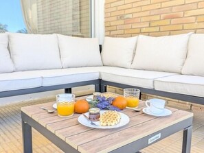 A breakfast setup with orange juice, waffles, honey, and a cup on a wooden table. - Villa Rübezahl + Independent Apartment (Benidorm)