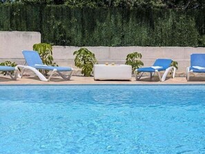 A swimming pool with lounge chairs and potted plants. - Villa Rübezahl + Independent Apartment (Benidorm)