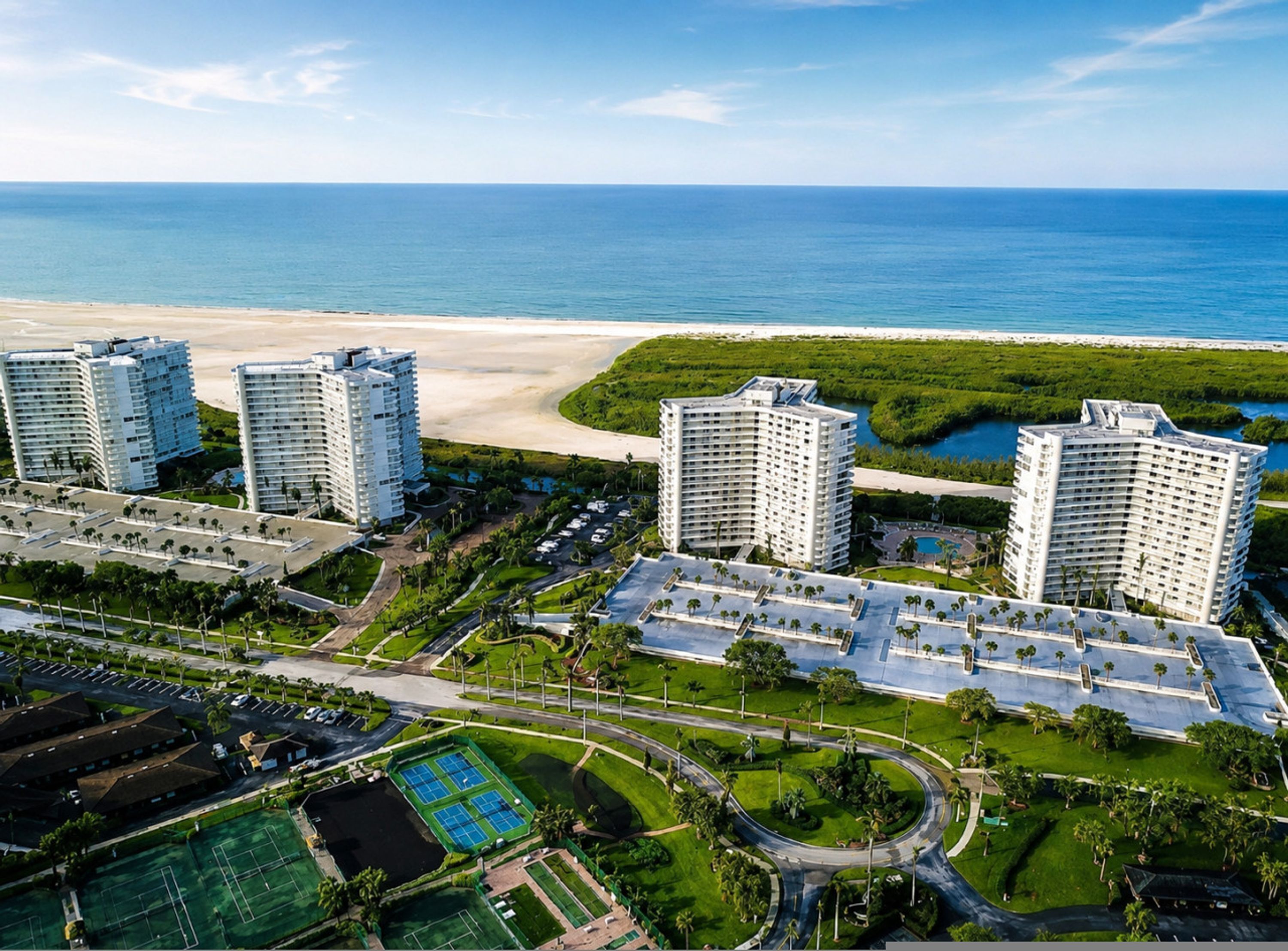 A coastal hotel complex with multiple high-rise buildings, a beach, and a marina.