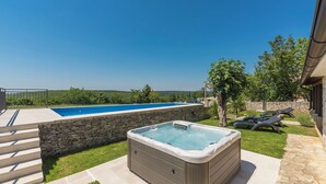A backyard with a swimming pool, a hot tub, and a stone wall. - Villa Ana Rita (Kanfanar)