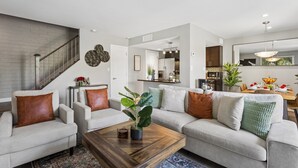 A modern living room with a staircase, a dining area, and a kitchen. - The Stirrup | New | Near Old Town + Pools (Scottsdale)