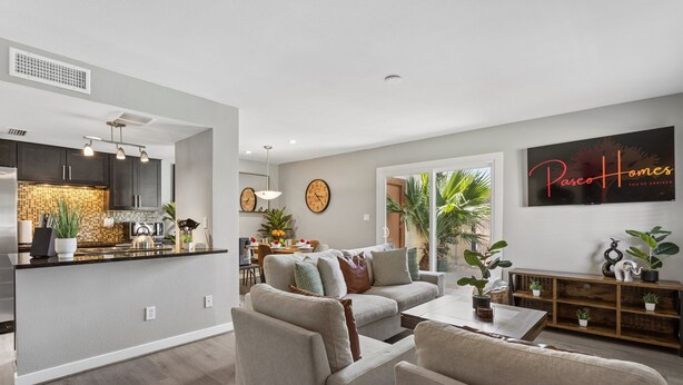 A modern living room with a sofa, coffee table, and a TV wall art. - The Stirrup | New | Near Old Town + Pools (Scottsdale)