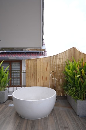 A large outdoor hot tub on a wooden deck with a bamboo fence and potted plants. - Lua Boutique Hotel & Spa - An Bang Beach (Da Nang)