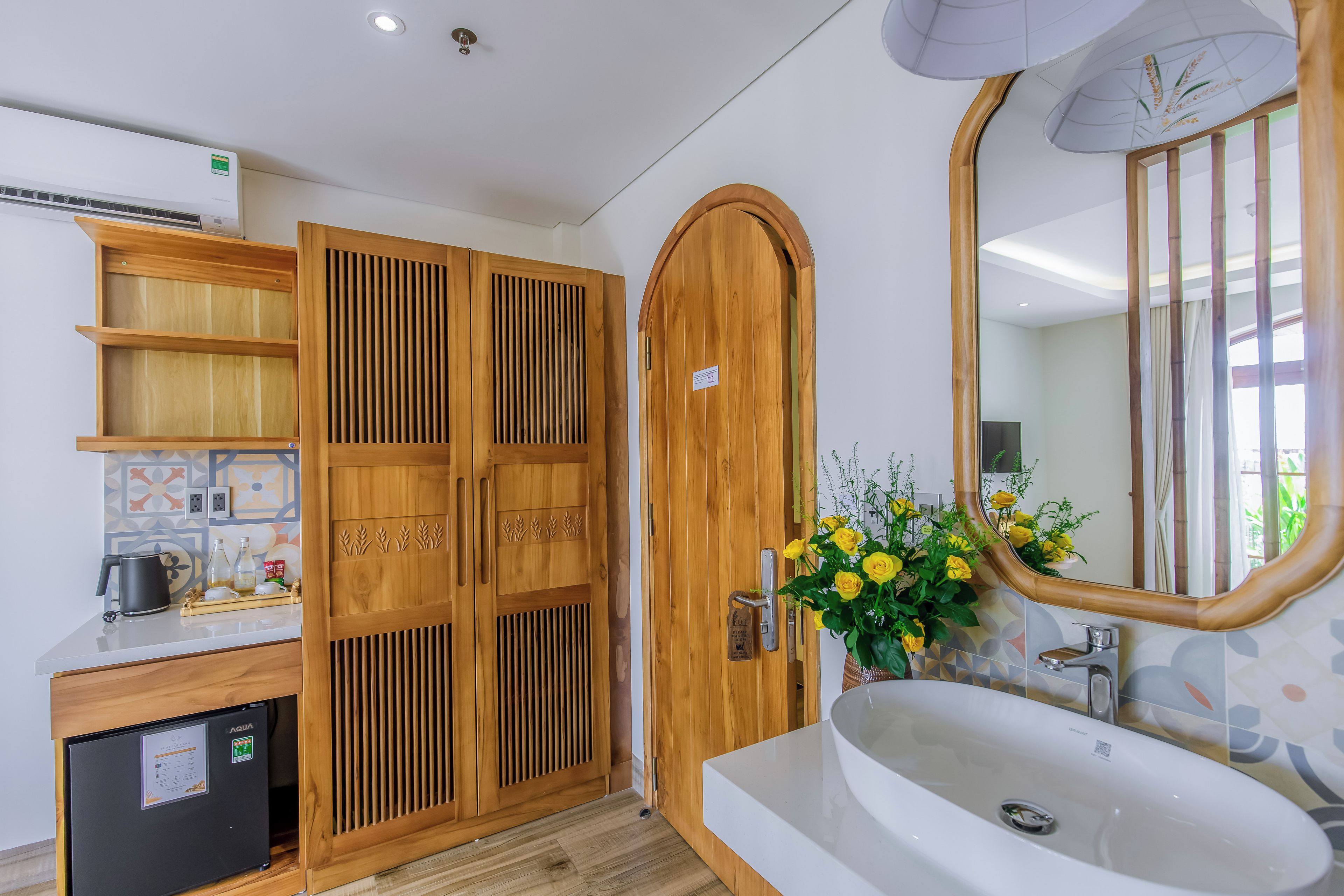 A modern bathroom with a wooden vanity, a sink, and a mirror.