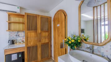 A modern bathroom with a wooden vanity, a sink, and a mirror.
