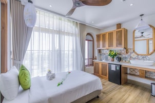 Una habitación de hotel con cama, kitchenette y baño.