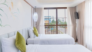 Habitación de hotel con dos camas, un ventanal grande, una lámpara en el techo y vistas al exterior.