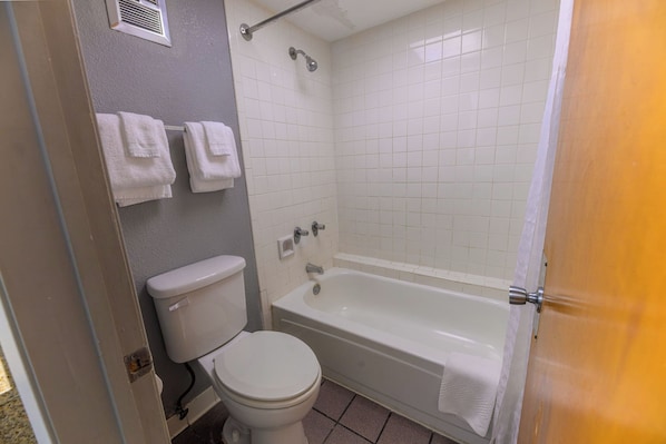 Une salle de bain comprenant des toilettes, une baignoire et une douche.