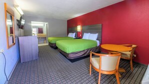 Una habitación de hotel con dos camas, un escritorio y una silla.