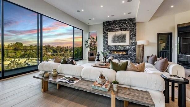 A modern living room with a large window, a fireplace, and a sofa set. - Casa Adriana by Oraklus (Pacific Palisades)