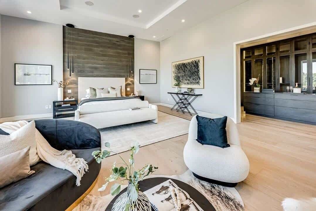 A modern living room with a bed, sofas, a coffee table, and artwork on the walls.