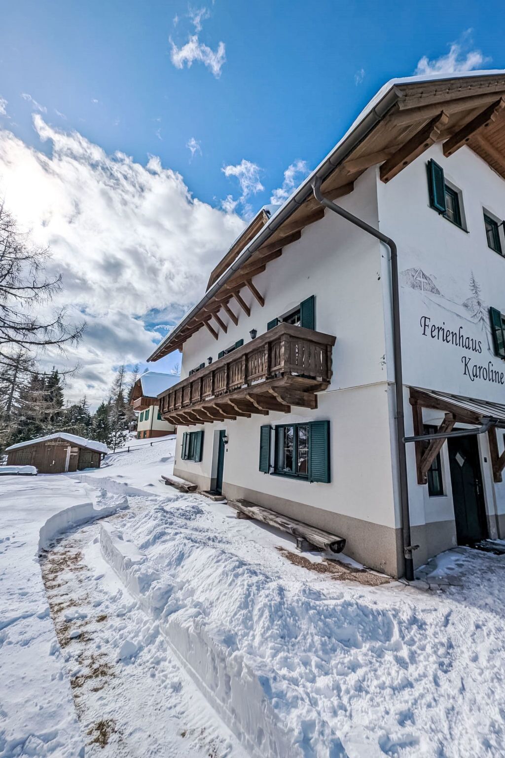 Un bâtiment blanc doté d’un balcon, de poutres en bois et d’une enseigne indiquant « Ferienhaus Karoline ».