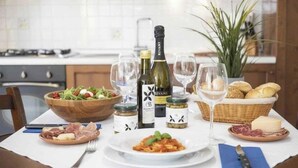 Ein Esstisch, gedeckt mit Speisen, Wein und Gläsern, in einer Küche.