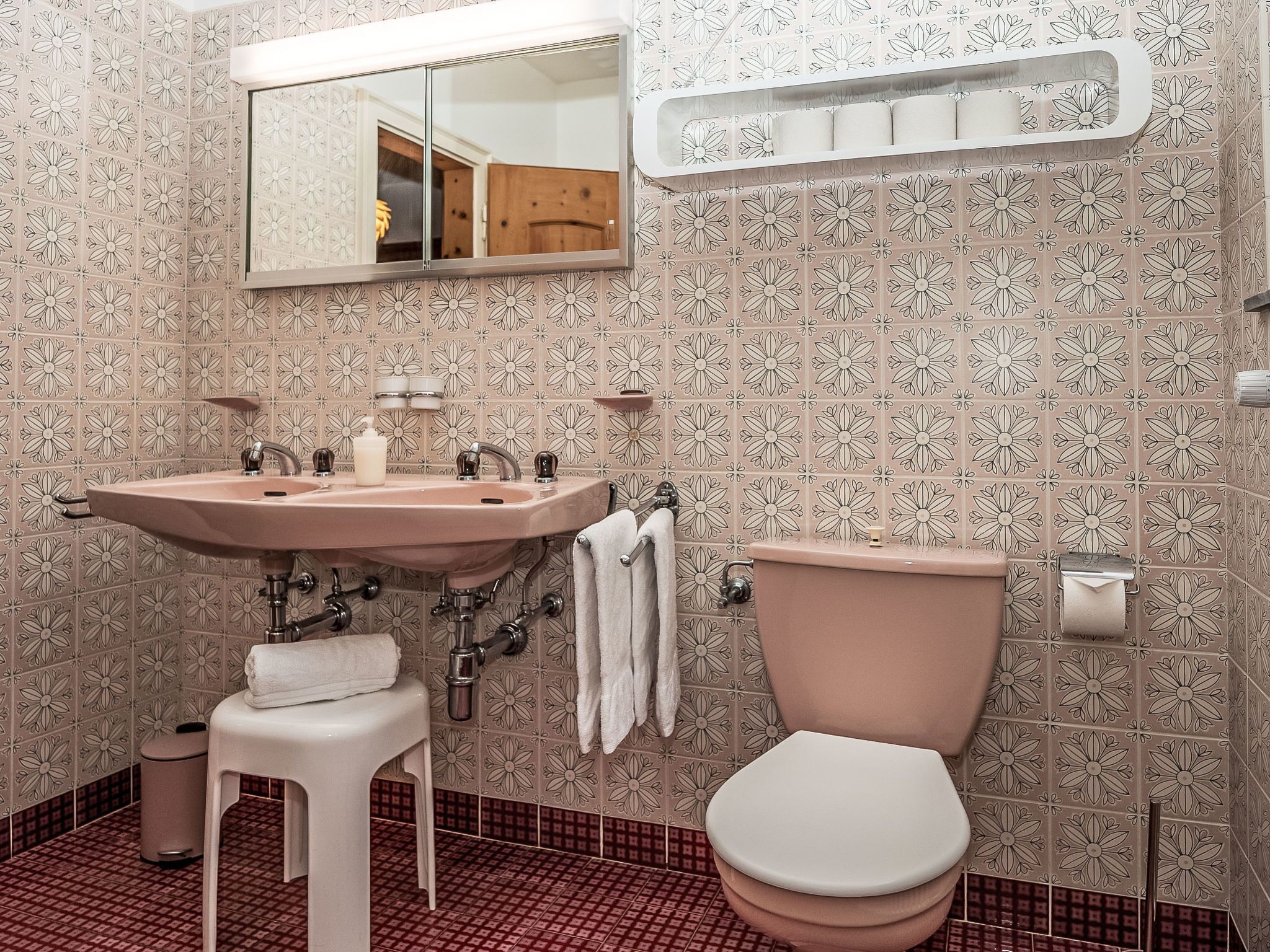 Une salle de bain avec un lavabo, des toilettes et un miroir.