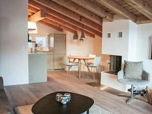A modern interior with a dining area, kitchen, and seating space. - Cocoon-Laax by Interhome (Laax)