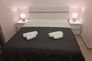 A hotel room with a bed, two bedside lamps, and two rolled towels on the bed. - Batur Pool Apartment A4, Zadar, Croatia (Zadar)