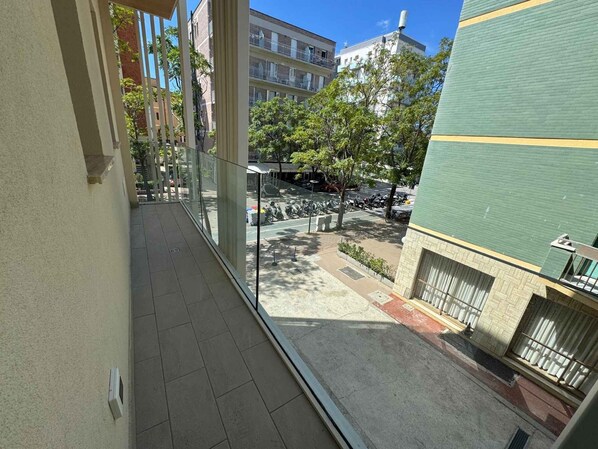 A balcony with a view of a street, buildings, and parked motorcycles. - Holiday apartment with air conditioning, balcony and internet (Pesaro)