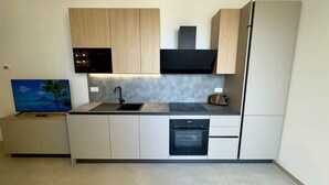 Uma cozinha moderna com forno embutido, micro-ondas e pia.