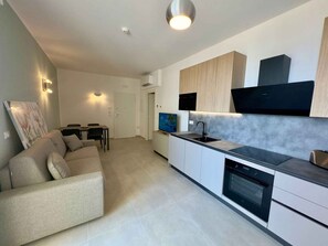 Eine moderne Küche mit Backofen, Spüle und Essbereich mit Tisch und Stühlen.
