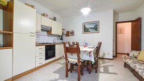 Una cocina compacta con una mesa y sillas, estufa y armarios.